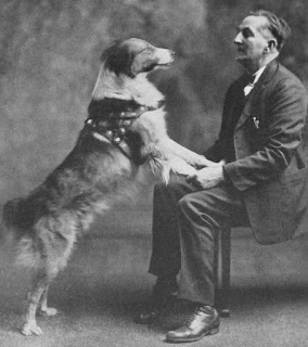 Frank Brazier sits in a chair as Bobbie rests his front paws on his lap.